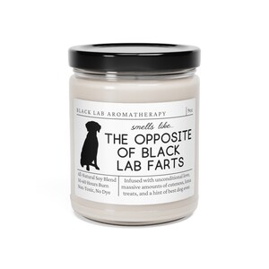 May include: A white candle jar with a black lid and label. The label reads "BLACK LAB AROMATHERAPY" and "smells like... THE OPPOSITE OF BLACK LAB FARTS". The label also includes the text "All-Natural Soy Blend, 50-60 Hours Burn, Non-Toxic, No Dye" and "Infused with unconditional love, massive amounts of cuteness, lotsa treats, and a hint of best dog ever."