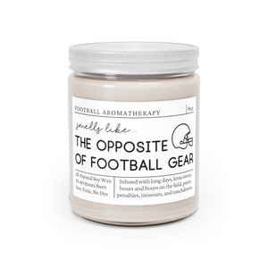 Może przedstawiać: Świeca o pojemności 9 uncji w szklanym słoiku ze srebrną pokrywką. Świeca jest beżowa i ma czarny tekst, kt&oacute;ry brzmi "Football Aromatherapy smells like... THE OPPOSITE OF FOOTBALL GEAR". Tekst kontynuuje "All-Natural Soy Wax 50-60 Hours Burn Non-Toxic, No Dye" i "Infused with long days, lotsa sweat, hours and hours on the field, punts, penalties, timeouts, and touchdowns."