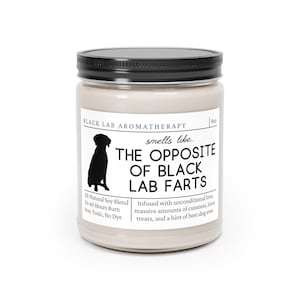 May include: A 9 oz candle in a glass jar with a black lid. The label is beige with black text that reads "Black Lab Aromatherapy" and "smells like... The Opposite of Black Lab Farts". The label also includes a silhouette of a black labrador retriever and the text "All-Natural Soy Blend, 50-60 Hours Burn, Non-Toxic, No Dye". The label also includes the text "Infused with unconditional love, massive amounts of cuteness, lotsa treats, and a hint of best dog ever."
