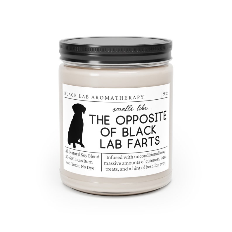 May include: A 9 oz candle in a glass jar with a black lid. The label is beige with black text that reads "Black Lab Aromatherapy" and "smells like... The Opposite of Black Lab Farts". The label also includes a silhouette of a black labrador retriever and the text "All-Natural Soy Blend, 50-60 Hours Burn, Non-Toxic, No Dye". The label also includes the text "Infused with unconditional love, massive amounts of cuteness, lotsa treats, and a hint of best dog ever."