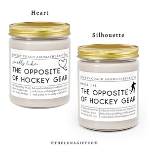 May include: Two soy wax candles with gold lids. The candles are labeled "Hockey Coach Aromatherapy" and have the text "The Opposite of Hockey Gear" on the front. The candles are infused with scents that smell like the opposite of hockey gear.