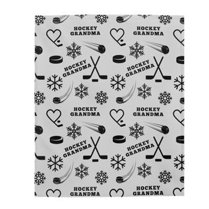May include: A gray and black patterned fabric with the text "Hockey Grandma" repeated throughout. The pattern includes hockey sticks, pucks, snowflakes, and hearts.