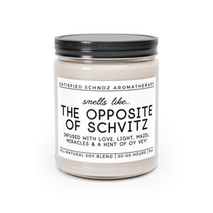 May include: A glass jar candle with a black lid and a white label that reads "SATISFIED SCHNOZ AROMATHERAPY smells like... THE OPPOSITE OF SCHVITZ INFUSED WITH LOVE, LIGHT, MAZEL, MIRACLES & A HINT OF OY VEY! ALL-NATURAL SOY BLEND 50-60 HOURS 9oz"