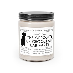 Może przedstawiać: Szklany słoik z beżową świecą, z czarną pokrywką i czarną sylwetką psa. Etykieta zawiera napis "Chocolate Lab Aromatherapy" i "The Opposite of Chocolate Lab Farts". Świeca jest wzbogacona o bezwarunkową miłość, urocze detale, smakołyki i nutę najlepszego psa na świecie. Wykonana jest z naturalnej mieszanki sojowej i pali się przez 50-60 godzin.