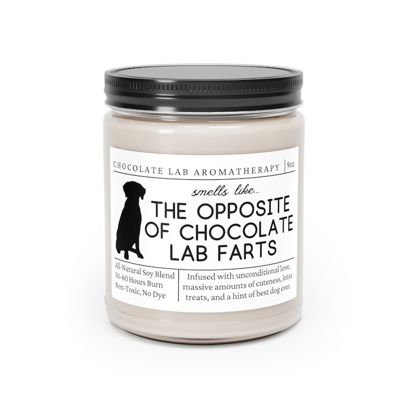 Może przedstawiać: Szklany słoik z beżową świecą, z czarną pokrywką i czarną sylwetką psa. Etykieta zawiera napis "Chocolate Lab Aromatherapy" i "The Opposite of Chocolate Lab Farts". Świeca jest wzbogacona o bezwarunkową miłość, urocze detale, smakołyki i nutę najlepszego psa na świecie. Wykonana jest z naturalnej mieszanki sojowej i pali się przez 50-60 godzin.