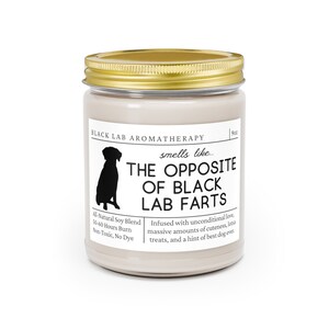 May include: A 9oz candle in a glass jar with a gold lid. The candle is beige and has a black silhouette of a dog on the front. The text on the label reads "Black Lab Aromatherapy" and "smells like... The Opposite of Black Lab Farts". The text below the dog silhouette reads "All-Natural Soy Blend, 50-60 Hours Burn, Non-Toxic, No Dye". The text below the candle name reads "Infused with unconditional love, massive amounts of cuteness, lotsa treats, and a hint of best dog ever."