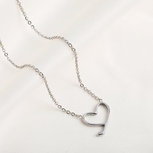 Op de afbeelding: Een zilveren ketting met een eenvoudige, open hart hanger.