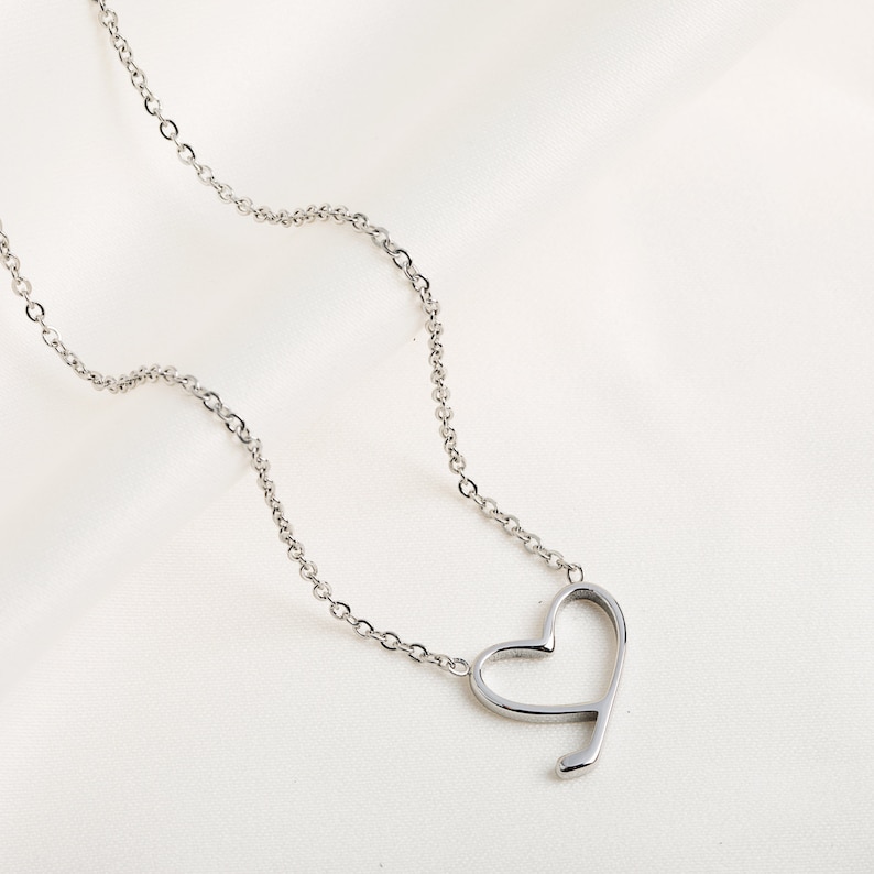 Op de afbeelding: Een zilveren ketting met een eenvoudige, open hart hanger.