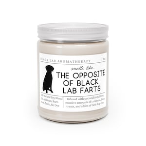 May include: A 9 oz candle in a glass jar with a silver lid. The candle is beige and has black text that reads "BLACK LAB AROMATHERAPY smells like... THE OPPOSITE OF BLACK LAB FARTS". The text also says "All-Natural Soy Blend 50-60 Hours Burn Non-Toxic, No Dye". Below the text is a black silhouette of a dog.