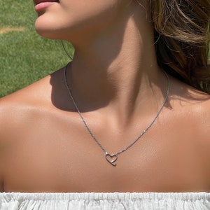 Op de afbeelding: Een zilveren ketting met een eenvoudige hart hanger.