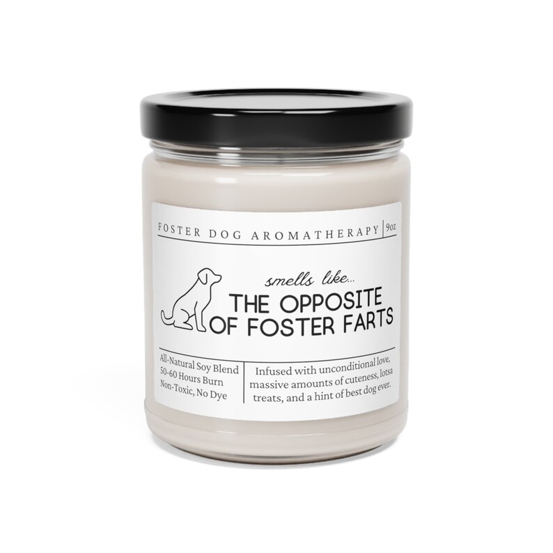 May include: A white candle jar with a black lid. The label reads "FOSTER DOG AROMATHERAPY 9oz" and "smells like... THE OPPOSITE OF FOSTER FARTS". The label also says "All-Natural Soy Blend, 50-60 Hours Burn, Non-Toxic, No Dye" and "Infused with unconditional love, massive amounts of cuteness, lotsa treats, and a hint of best dog ever."