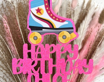 May include: Pink glitter cake topper with the words "Happy Birthday Chloe" and a blue, red, and yellow roller skate.