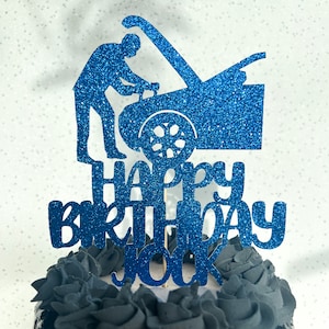 Puede incluir: Topper para pastel de purpurina azul con una silueta de una persona trabajando en un coche y el texto "Happy Birthday You".