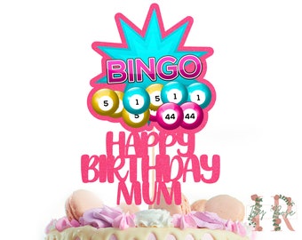 May include: Pink and blue glitter cake topper with the words "Bingo" and "Happy Birthday Mum" and bingo balls with numbers 1, 5, and 44.