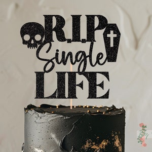 May include: Black cake topper with glitter accents. The topper says "RIP Single Life" with a skull and a coffin.