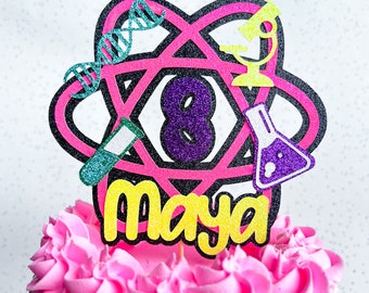 Decoración para tartas de cumpleaños personalizadas con purpurina y temática científica.
