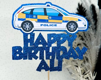Könnte beinhalten: Blau-weißer Polizeiauto-Kuchentopper mit den Worten "Happy Birthday Ali" in blauen Glitzer.