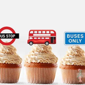 May include: Three cupcakes decorated with a red double-decker bus, a red circle with "BUS STOP" text, and a blue sign with "BUSES ONLY" text.