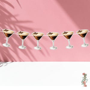 May include: A string of brown and white coffee cocktail party decorations with a coffee bean on top of each drink. The decorations are strung together with white string.