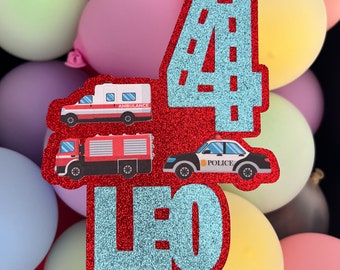 Könnte beinhalten: Roter Glitzer-Kuchentopper mit einer blauen Zahl vier, einem Feuerwehrauto, einem Krankenwagen, einem Polizeiauto und dem Namen Leo. Die Zahl vier hat ein Straßenmuster im Inneren.