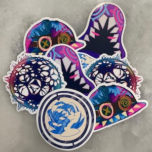 May include: A set of six colorful stickers featuring abstract designs with a variety of shapes, patterns, and colors. The stickers are printed on white vinyl and have a glossy finish.