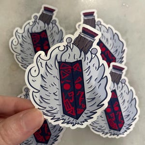 May include: A collection of stickers featuring a stylized design. Each sticker has a central rectangular element with red and blue patterns, topped with a brown and red element, and surrounded by a white, cloud-like shape.