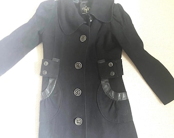 May include: A black wool coat with a collar and long sleeves. The coat has a button closure and two pockets with leather trim. The coat has a brand label with the text "NYM" on the inside.