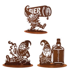 Può includere: Tre gnomi da giardino in metallo marrone. Uno gnomo porta una lattina di birra con la scritta "BIER". Un altro gnomo fuma una pipa. Il terzo gnomo si appoggia a una bottiglia di whisky con la scritta "WHISKEY".