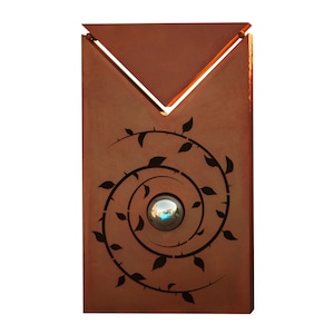 Könnte beinhalten: Eine rostige Metallskulptur mit einem kreisförmigen Design, das eine sich drehende Rebe mit Blättern und eine kleine blaue Glaskugel in der Mitte zeigt. Die Skulptur hat eine dreieckige Spitze.