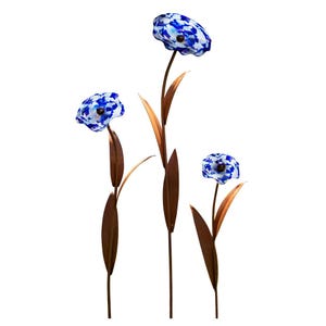 Könnte beinhalten: Drei dekorative Gartenstecker mit blau-weiß gemusterten Glaskopfblüten an schlanken, kupferfarbenen Metallstielen. Jeder Stiel ist mit spitz zulaufenden, kupferfarbenen Blättern versehen, was ein Set aus drei verschiedenen Blumenskulpturen ergibt.
