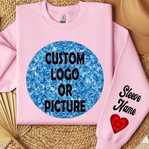 May include: Pink sweatshirt with a customizable design.  A large circle graphic on the front displays the text 