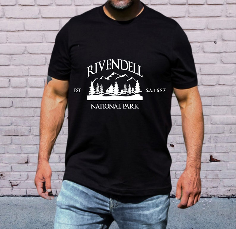 May include: Black t-shirt with a white graphic of a mountain range and trees. The graphic says "Rivendell National Park" with "Est" and "S.A. 1697" on either side.