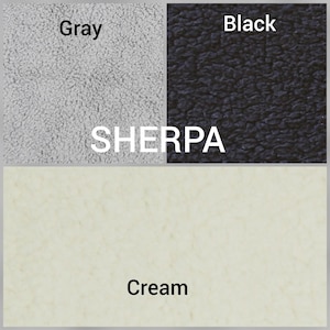 May include: A display of sherpa fabric swatches in three distinct colors. The top left section is gray, the top right section is black, and the bottom section is cream. The word SHERPA is printed in white text across the center of the image.