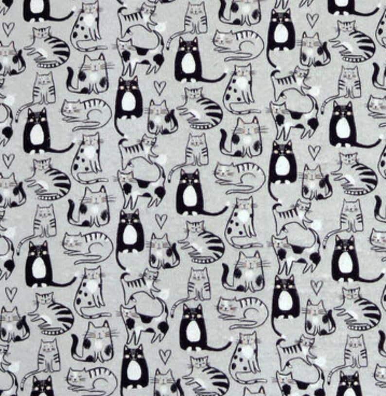 May include: A light gray fabric featuring a repeating pattern of various cats in black, white, and gray tones. The design includes sitting and lying cats with striped, spotted, and solid markings, interspersed with small black heart outlines.