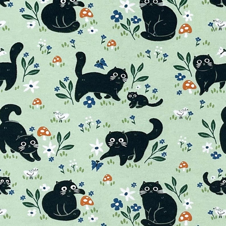 May include: A light green fabric featuring a repeating pattern of black cats in various poses, interspersed with orange mushrooms, small white and blue flowers, green leaves, blue butterflies, and tiny white birds scattered across the surface.