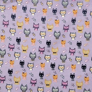 May include: A light purple fabric featuring a repeating pattern of small, stylized cat faces in various colors including black, orange, grey, and pink, interspersed with tiny fish icons. Some cats wear glasses or bow ties, creating a dense, uniform design.