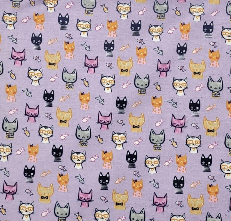 May include: A light purple fabric featuring a repeating pattern of small, stylized cat faces in various colors including black, orange, grey, and pink, interspersed with tiny fish icons. Some cats wear glasses or bow ties, creating a dense, uniform design.