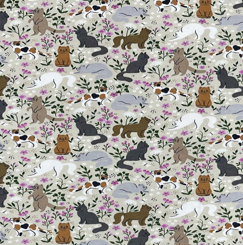May include: A light gray fabric featuring a repeating pattern of cats in various colors including black, white, brown, and calico. The cats are depicted in different poses among small green leafy plants and clusters of tiny pink and white flowers.