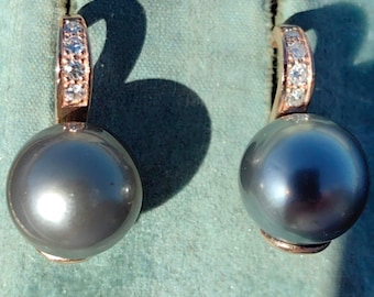 May include: A pair of black pearl earrings with a rose gold setting and a row of small diamonds on each earring.