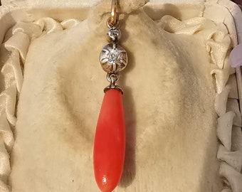 May include: A delicate pendant featuring a teardrop-shaped coral gemstone, suspended from a gold chain with a small diamond accent.