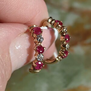 Peut inclure: Une paire de boucles d'oreilles créoles en or avec des rubis rouges et de petits diamants alternés.