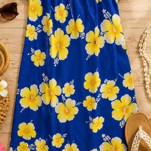 May include: A knee-length blue dress featuring a vibrant yellow hibiscus flower pattern throughout. The garment has short puff sleeves, a V-neckline, and a label at the inner collar that reads Hilo Hattie. The fabric displays a repeating floral print.