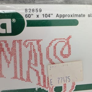 Puede incluir: Un paquete con la marca "Illa" en letras blancas sobre un fondo verde. El paquete est&aacute; etiquetado como "60" x 104" Approximate size" (152 cm x 264 cm) y tiene un dise&ntilde;o bordado en rojo. Se adjunta una peque&ntilde;a etiqueta de precio.