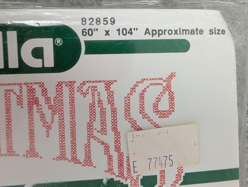 Puede incluir: Un paquete con la marca "Illa" en letras blancas sobre un fondo verde. El paquete est&aacute; etiquetado como "60" x 104" Approximate size" (152 cm x 264 cm) y tiene un dise&ntilde;o bordado en rojo. Se adjunta una peque&ntilde;a etiqueta de precio.