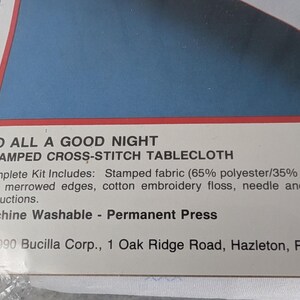 Puede incluir: Paquete para un kit de mantel de punto de cruz estampado. El texto dice "To All A Good Night". El kit incluye tela estampada, hilo de bordar y una aguja. La tela es 65% poli&eacute;ster y 35% algod&oacute;n.