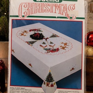 Puede incluir: Kit de mantel de punto de cruz navide&ntilde;o Bucilla. La tela blanca presenta un dise&ntilde;o de &aacute;rbol de Navidad en la esquina y un borde festivo con renos, &aacute;rboles y Pap&aacute; Noel. El paquete est&aacute; etiquetado 152 cm x 264 cm.