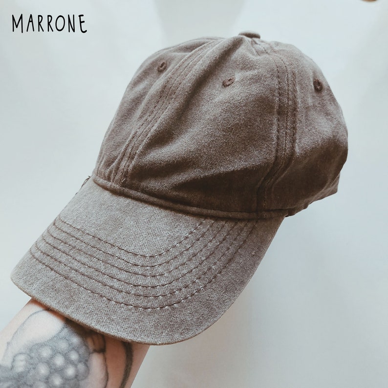 K&ouml;nnte beinhalten: Eine braune Baseballkappe mit leicht abgenutztem Look. Die Kappe hat einen gebogenen Schirm und ein gesticktes Design auf der Vorderseite.