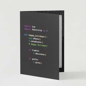 May include: A folded greeting card with a dark gray cover featuring computer code in green, purple, and white. The code includes "import joy", "Happy Holidays!", and other programming commands. The right side of the card has a binary code pattern.