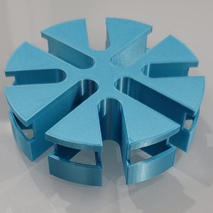 May include: A light blue plastic cable organizer with six slots. The organizer is shaped like a star with rounded points.