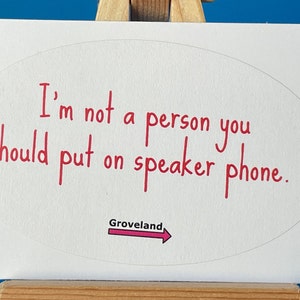May include: White sticker with a red oval containing the text "I'm not a person you should put on speaker phone."  Below the oval is a red arrow with the word "Groveland" written above it.